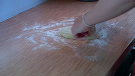 woman rolling out dough on wooden countertop