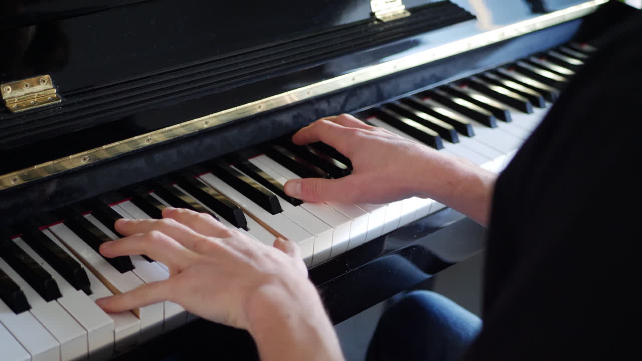 un pianista tocando una pieza musical en el teclado de un instrumento de piano