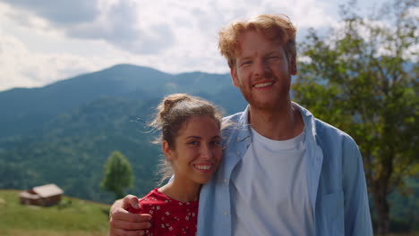 portrait couple looking camera in mountain. happy pair enjoying summer vacation.