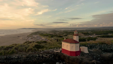 Nahaufnahme-Des-Coquille-River-Lighthouse-In-Bandon,-Oregon-Mit-Wellen,-Die-Am-Nachmittag-Auf-Die-Felsen-Spritzen---Drohnenaufnahme