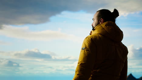 determined climber pauses to admire the scenic view with mountains and vast sky