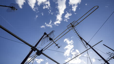 A timelapse of the sky and clouds with television aerials in the foreground