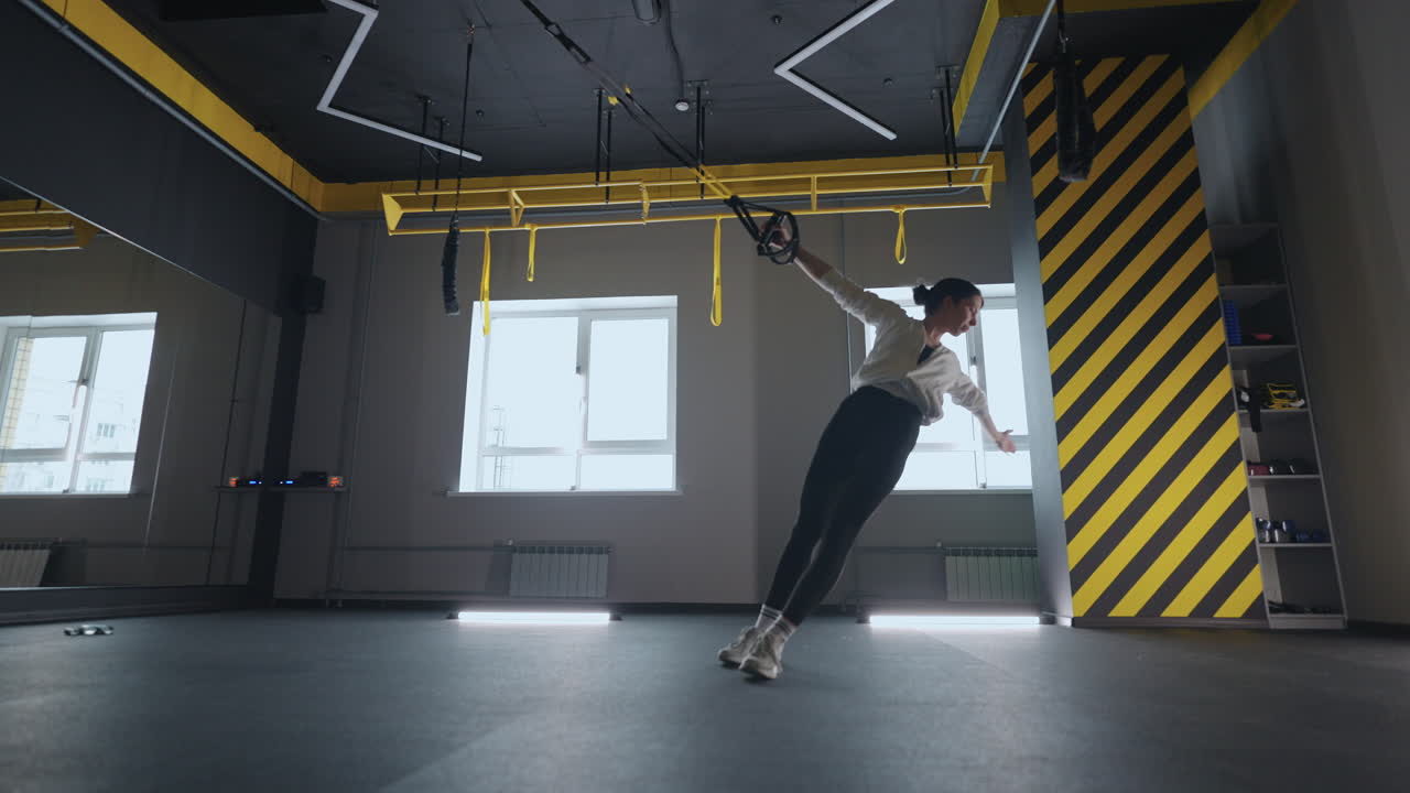 mujer de fitness ejercicio de entrenamiento con equipo trx en el gimnasio de fitness estilo de vida saludable construcción de cuerpo fuerte y en forma. mujer atractiva haciendo entrenamiento de core abs crossfit con correas de fitness en el gimnasio