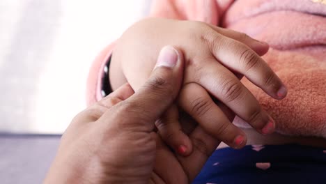 Father-holding-hand-of-baby-child,-close-up