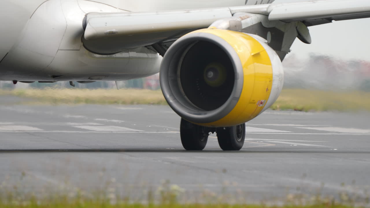 Close-up view of aircraft landing gear and engine on runway