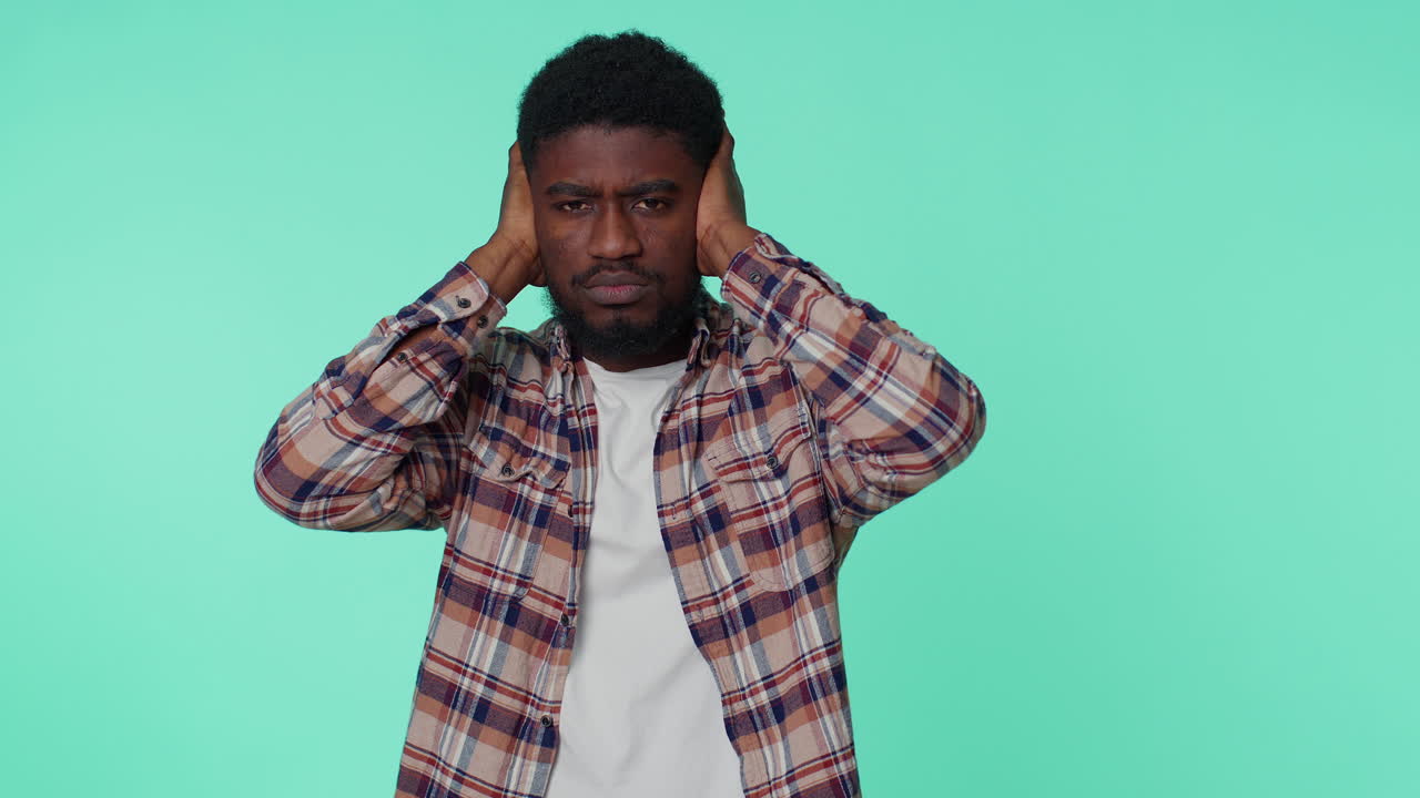 Frustrated irritated man covering ears, avoiding advice ignoring unpleasant noise loud voices