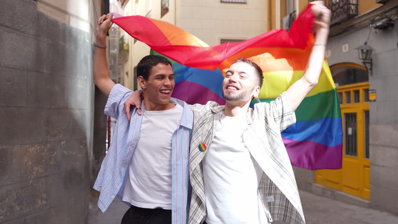 Happy Gay Couple Holding Rainbow Flag in City Street