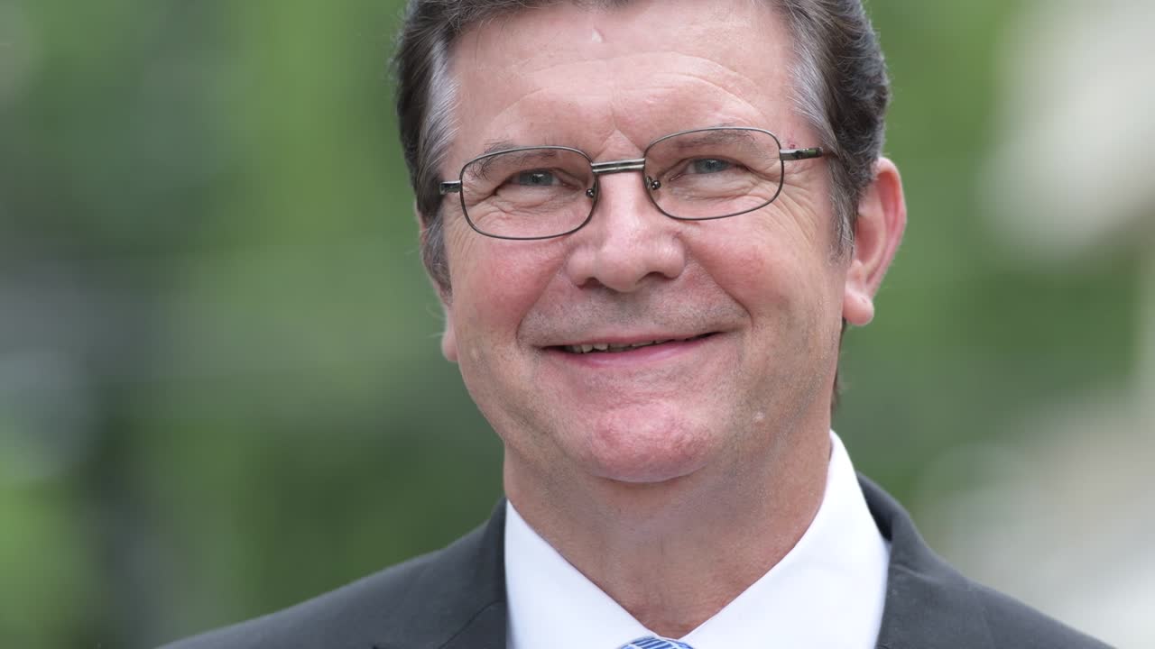 Happy handsome senior businessman smiling in the streets outdoors
