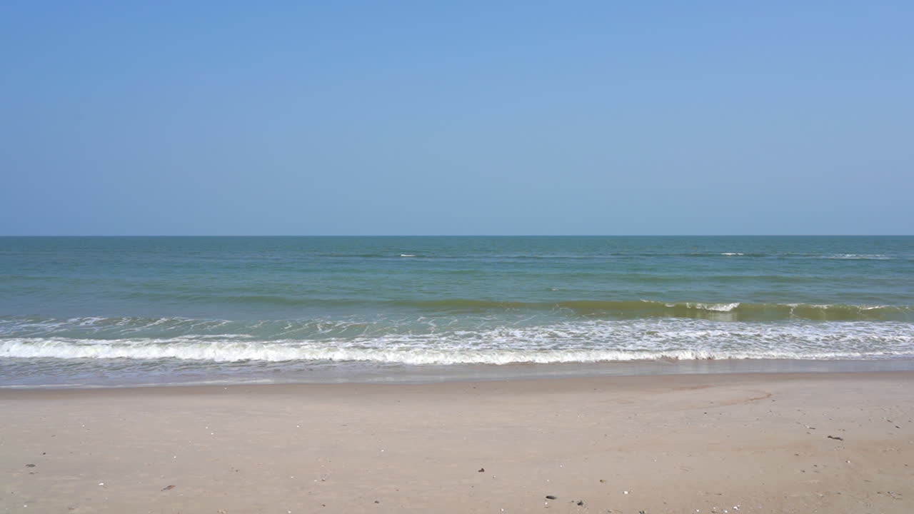 Slow motion of light tropical sea waves breaking on exotic white sand beach with clear skyline view, 120fps