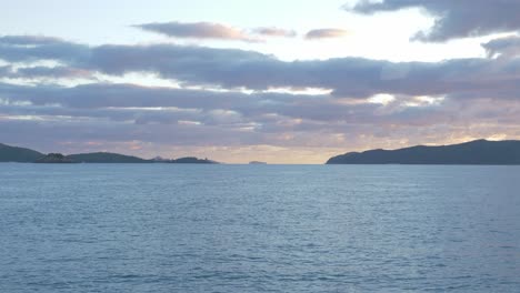 Vista-Lejana-De-Las-Islas-Whitsunday-En-La-Costa-Del-Mar-De-Coral-Bajo-Un-Cielo-Nublado-En-Queensland,-Australia