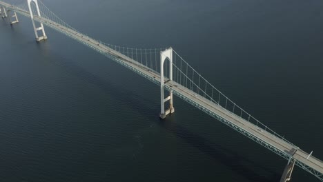 drone shot of a big bridge that crosses the water, moving to the right and slowly tilting down