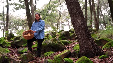 woman attentively looking at camera with mushroom in woods