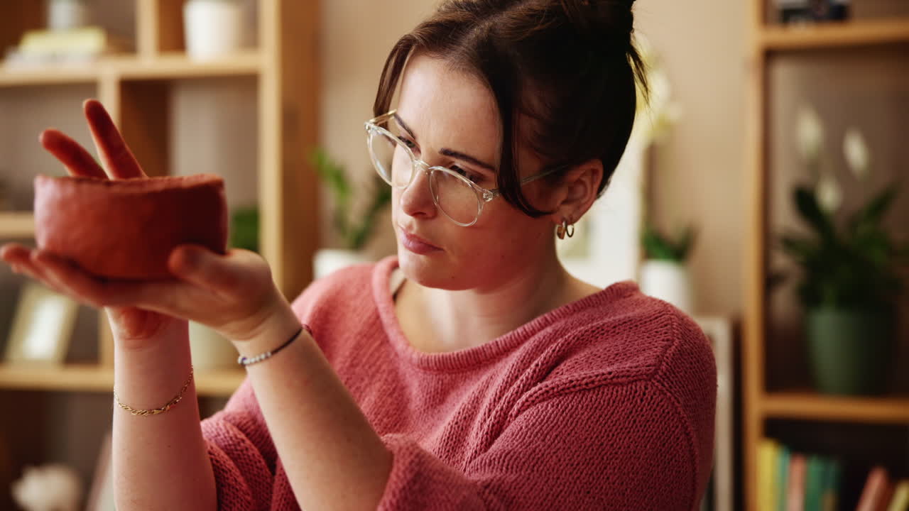 mujer examinando un cuenco de arcilla hecho a mano