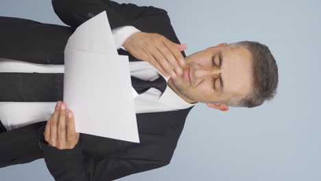 Vertical-video-of-Businessman-examines-paperwork-and-gets-upset.