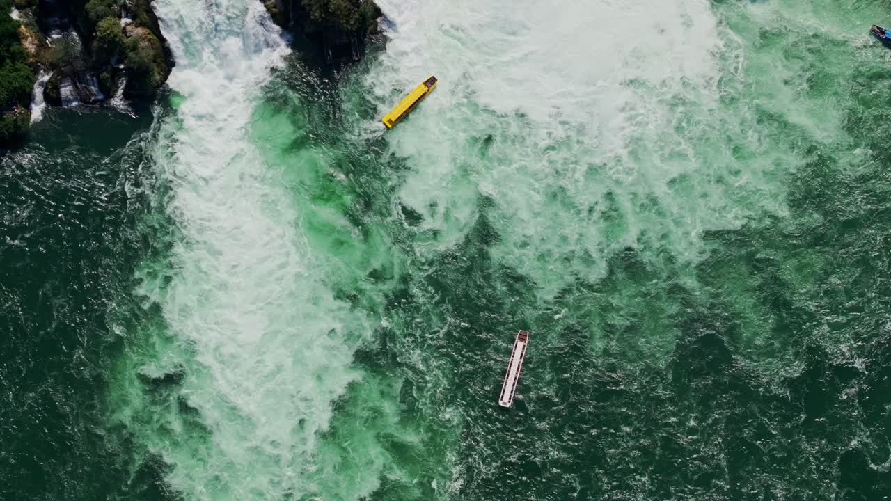 Dramatic aerial view of tourist boats in turbulent waters at Rhine Falls