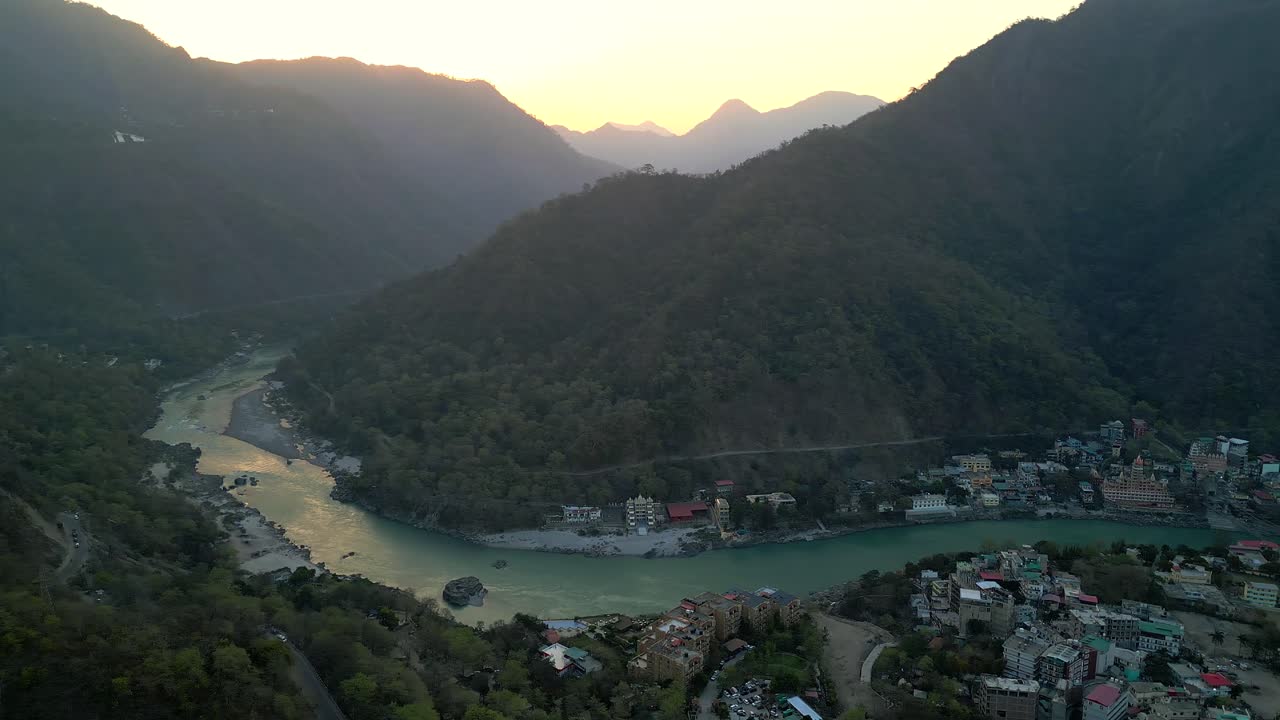 Hermoso amanecer detrás de las montañas en Rishikesh, vista de dron moviéndose de izquierda a derecha en India.