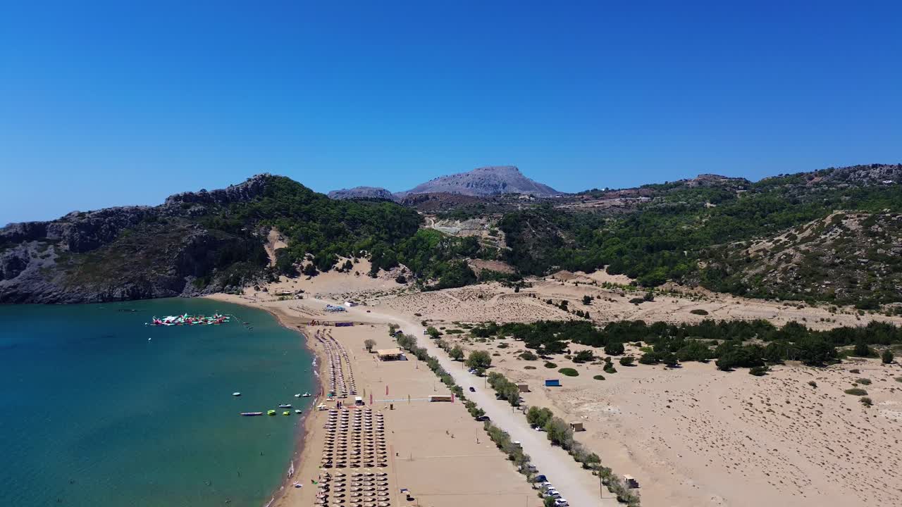 Tsambika beach in Faliraki, Rhodes in Greece filmed with the drone from above with Mediterranean Sea in the summer holiday