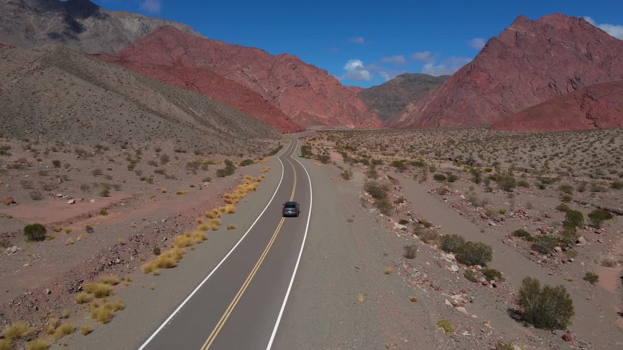 Toma de dron siguiendo un coche gris conduciendo hacia la Quebrada las Angosturas en Catamarca, Argentina