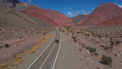 drone filmado siguiendo un coche gris que se dirige hacia la quebrada las angosturas en catamarca, argentina