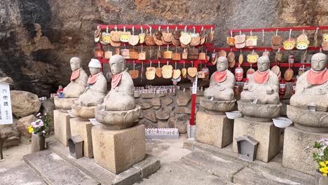 jizo statues at a huge rock in onomichi temple in japan