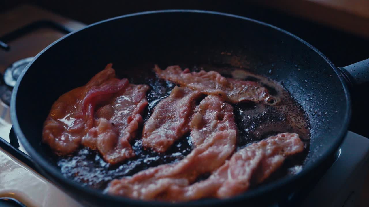 Bacon Sizzles in a Pan in a Rustic Kitchen in Reinsjøen, Åfjord, Trøndelag, Norway - Close Up