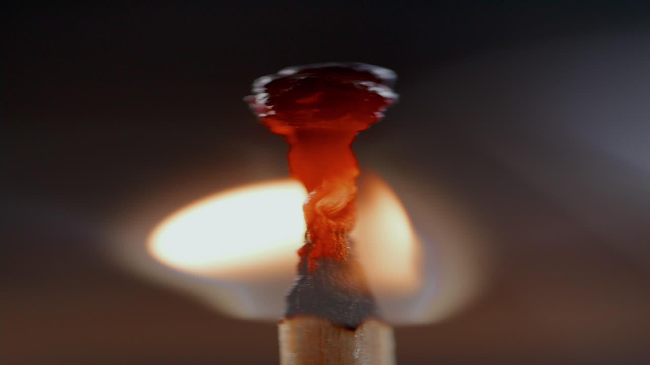 Vertical of Matchstick Melting in Flame against Dark Background