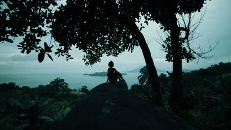 woman on a cliff overlooking the ocean