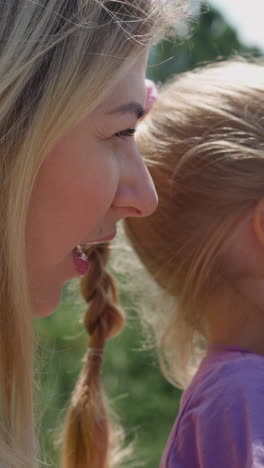 happy blonde lady with child looking through tower viewer spending time together on observation deck on sunny day close side view slow motion