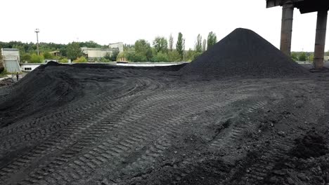 warehouse of coal inventory plant. yellow tractor loading the coal on the warehouse