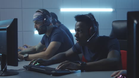 of multicultural female cybersport team winning game and cheering medium shot of young muslim female gamer and asian teammate playing in online video game with tense and focused look winning match cheering and pumping fists while celebrating victory