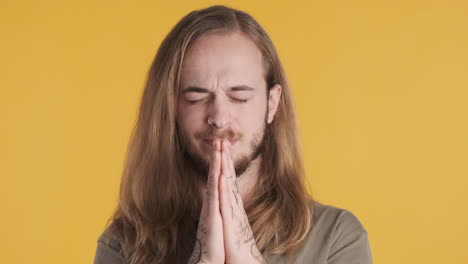 caucasian young man making a wish in front of the camera.