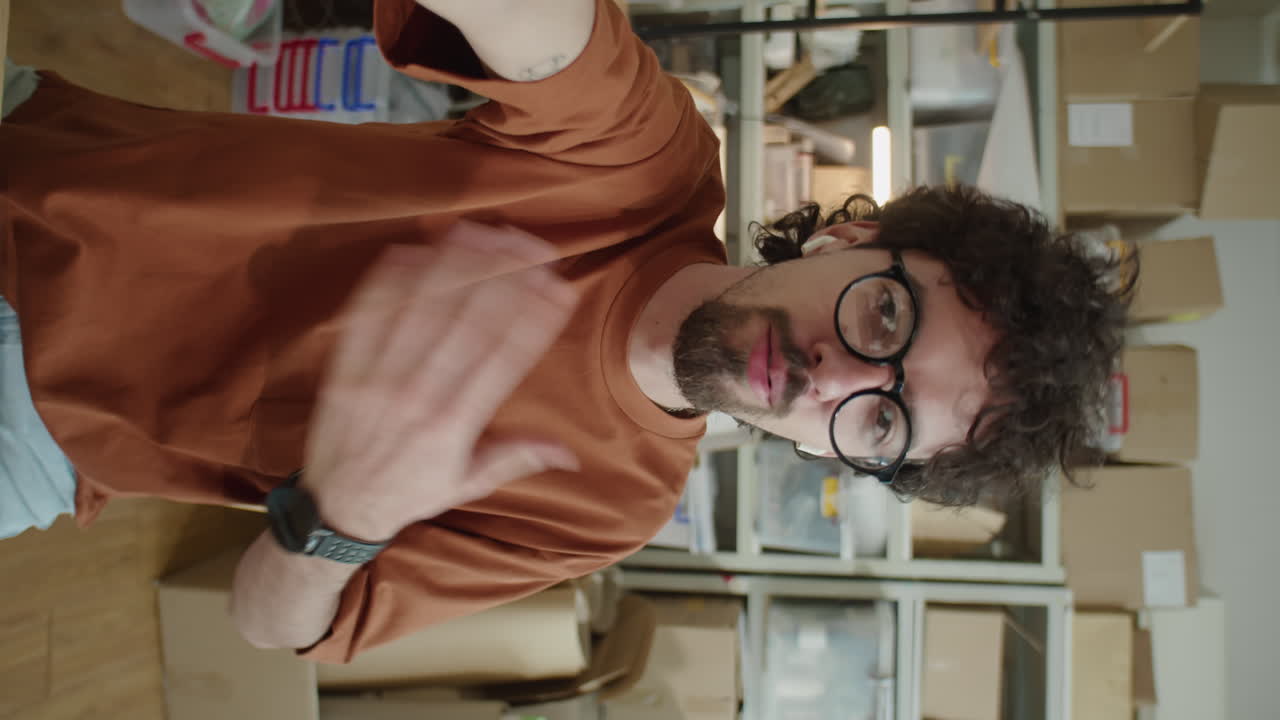 Young Male Worker Speaking on Camera in Online Store Warehouse