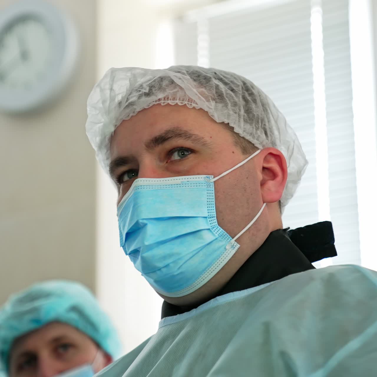 Surgeon commenting the process of operation to another doctor. Close-up portrait of a practicing surgery specialist