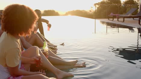 Happy-diverse-friends-with-drinks-talking-at-pool-in-slow-motion