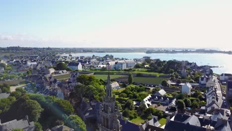 Flying-downwards-and-panning-up-towards-the-sea,-with-a-belltower-as-subject