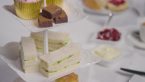 toma de estudio del tradicional té de la tarde británico con sándwiches, pasteles, bollos, crema y mermelada