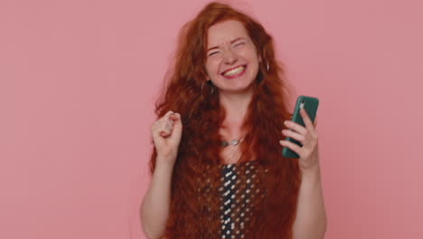 mujer feliz y emocionada usa el teléfono móvil y dice wow, sí, descubrí una gran noticia sobre una gran victoria haciendo un gesto de ganador