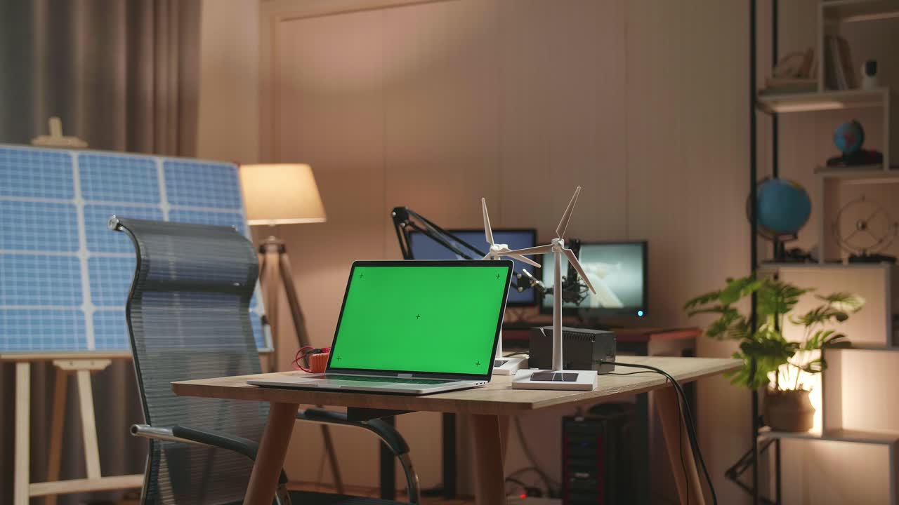 Green Screen Laptop And Wind Turbine On The Table Next To The Solar Cell At The Office