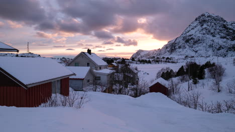 sunset behind small, snowy village in northern norway