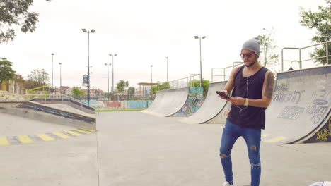 Young-boy-taking-a-selfie-in-a-skate-park-with-graffiti-on-background