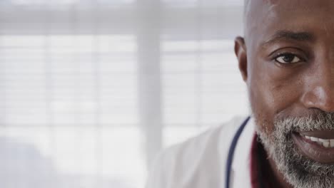 portrait of african american male doctor wearing lab coat and stethoscope, copy space, slow motion