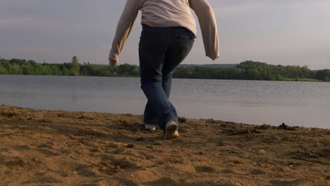 mujer solitaria camina hacia la orilla del lago y se sienta en un plano amplio