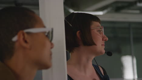 close up of female film director and assistant watching actor on monitor shooting movie or video scene in studio