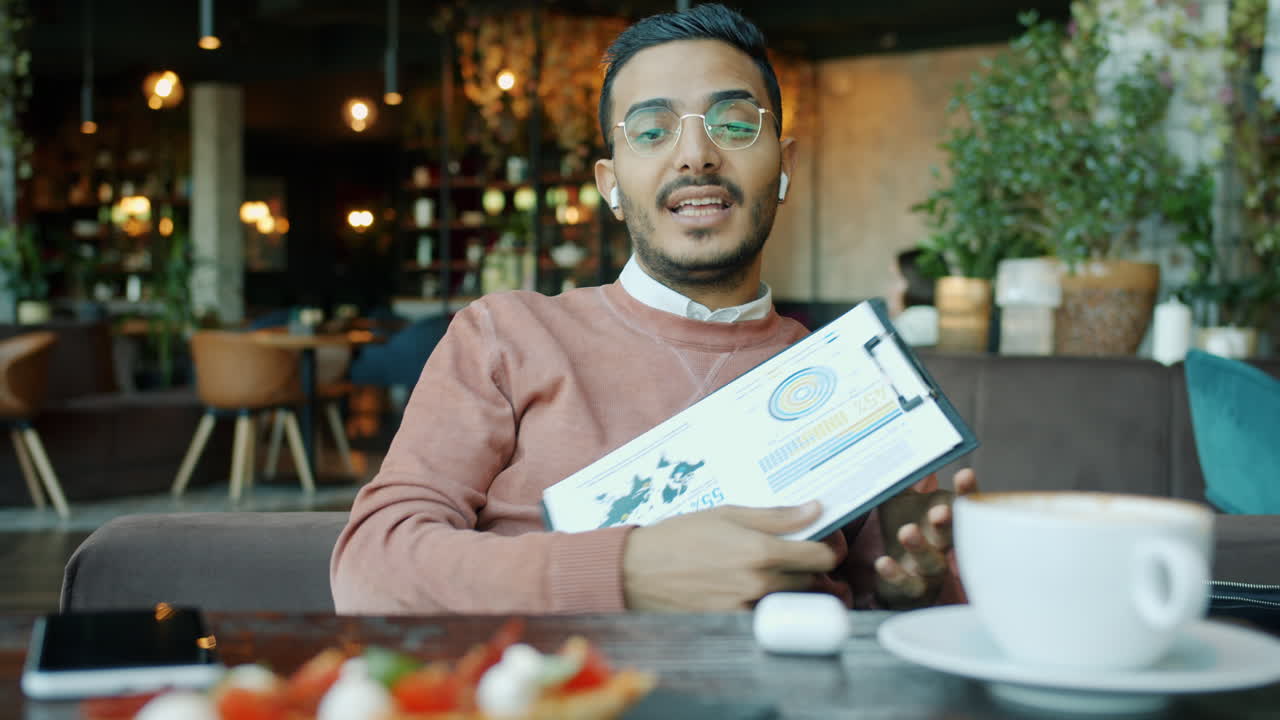 Businessman Presenting Data in a Cafe