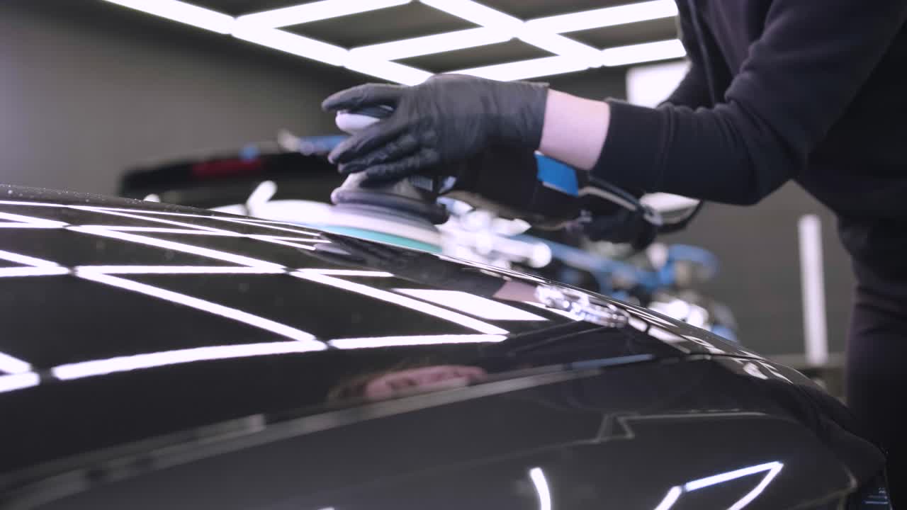Professional car detailing using machinery and polishers for paint restoration.