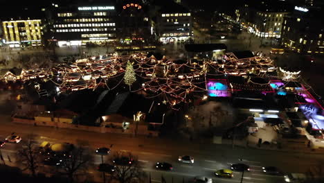 toma de drones del mercado navideño en zúrich, suiza volando hacia atrás y revelando el mercado por la noche