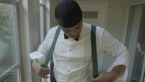 Groom-putting-on-suspenders-on-his-wedding-day