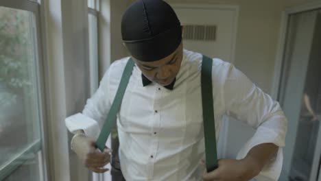 novio poniéndose tirantes el día de su boda