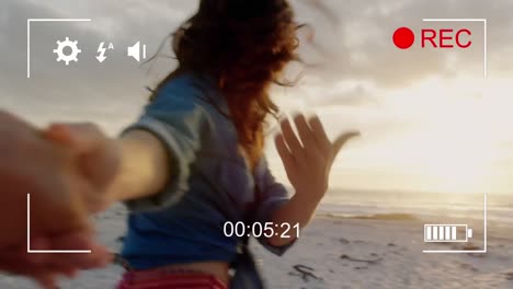 filmando a una mujer en una playa con una cámara digital