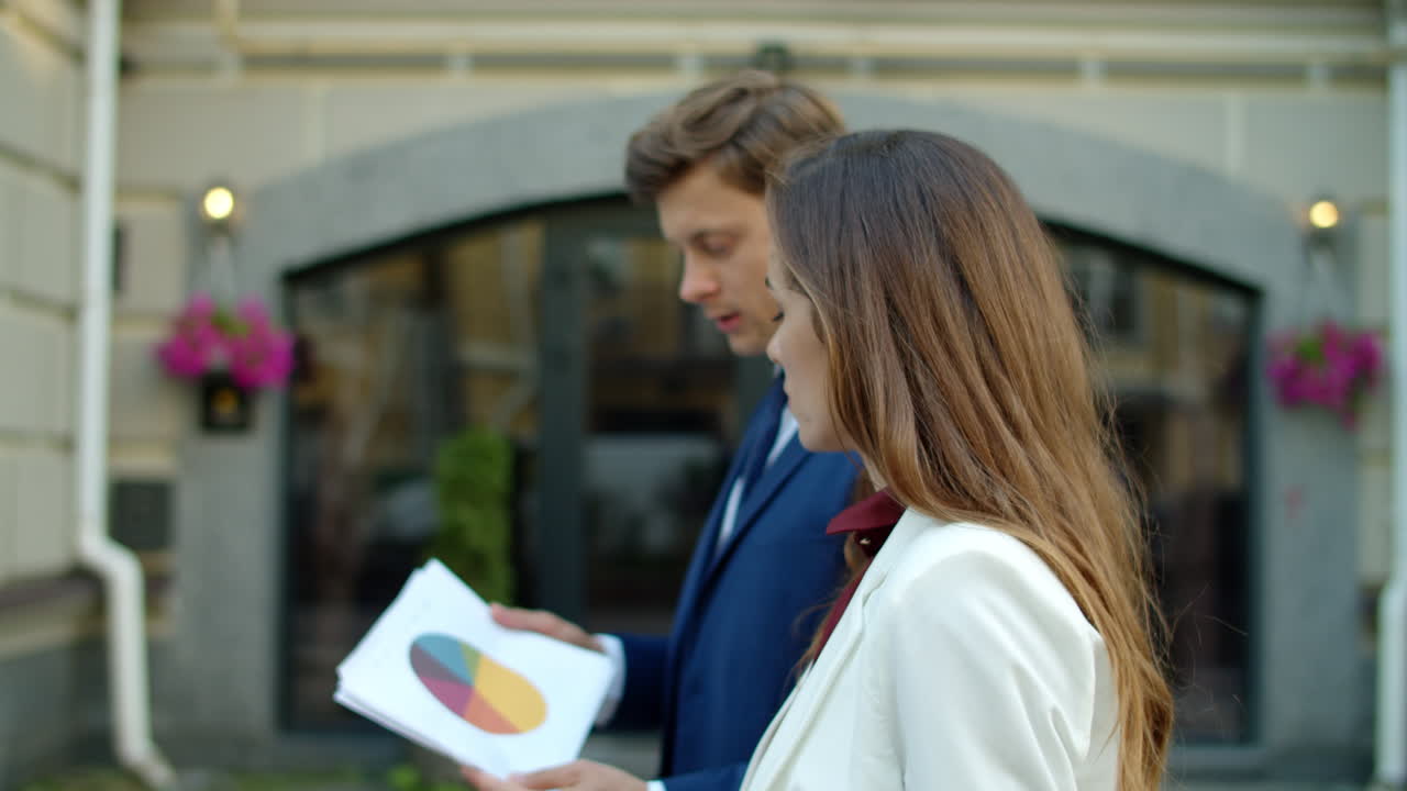 pareja de negocios enfocada analizando datos en documentos al aire libre